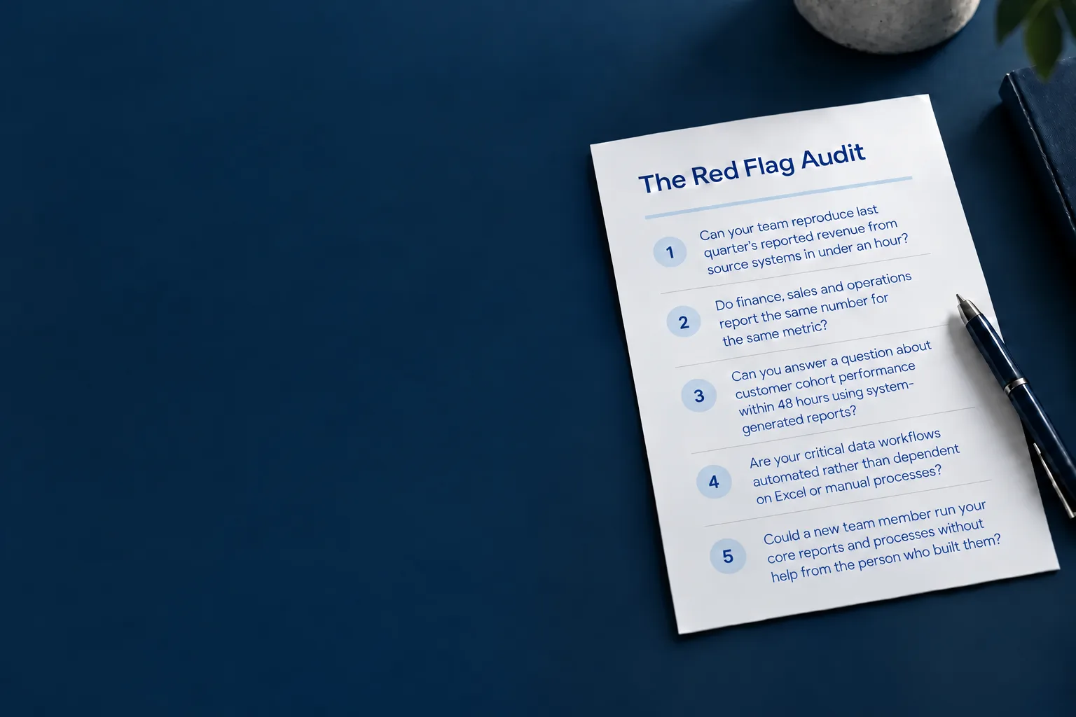 The Red Flag Audit, its five questions printed on one sheet, on a navy desk beside a pen